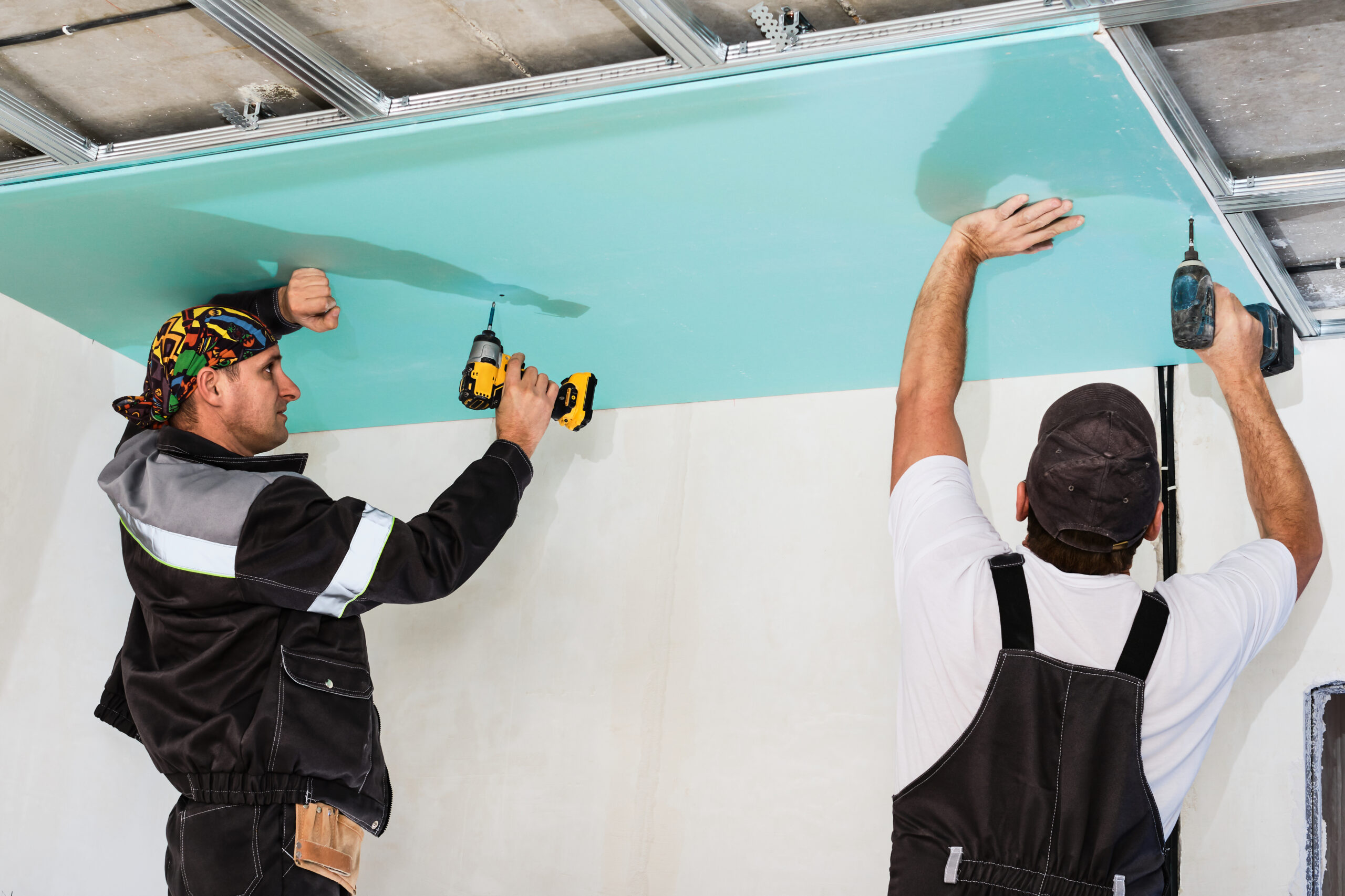 Plasterboard installers assembling drywall for a false ceiling